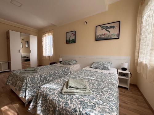 a bedroom with two beds and a window at Patrick House in Tivat