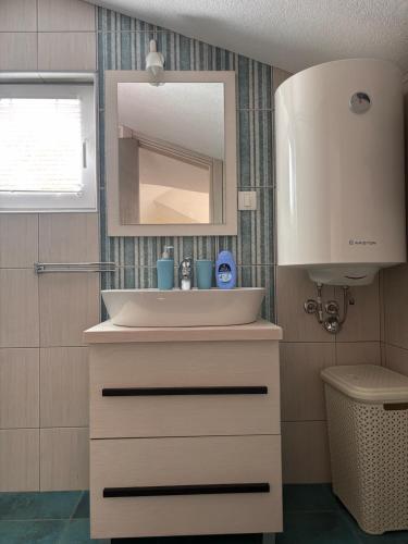 a bathroom with a white sink and a mirror at Patrick House in Tivat