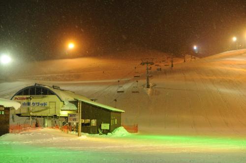 a snow covered ski slope at night with a ski lift at Kannabe Highland Hotel in Toyooka