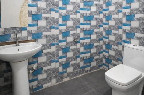 a bathroom with a toilet and a sink at Drop Hills Farm Noida in Noida