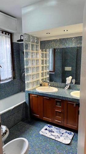 a bathroom with two sinks and a mirror at Lavilletta stanza parco in Baranzate