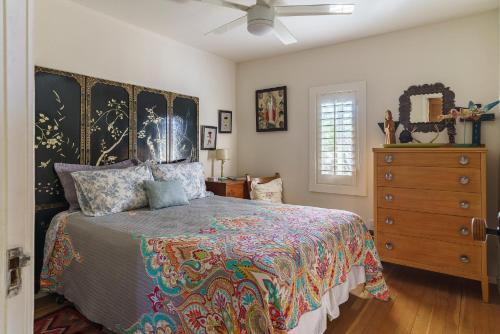 a bedroom with a bed with a large headboard and a dresser at Cactus Adobe in Twentynine Palms