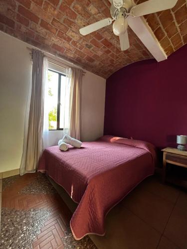 a bedroom with a bed with a ceiling fan at Casa Ttorrez in San Miguel de Allende