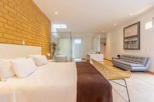 a bedroom with a large bed and a brick wall at Hotel Alma in Tinjacá