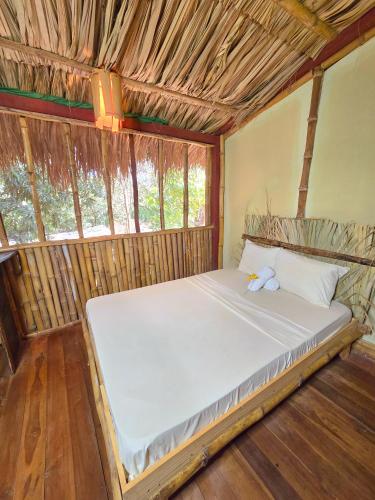 a bedroom with a bed in a straw hut at Tyler's place in Coco