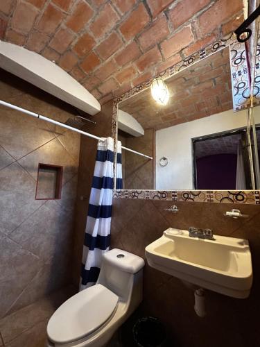 ein Badezimmer mit Toilette und Waschbecken in der Unterkunft Casa Ttorrez in San Miguel de Allende