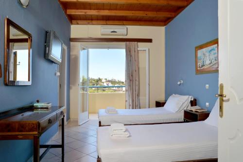 a hotel room with two beds and a window at Vagia Beach Apartments, Aegina Island in Vaia