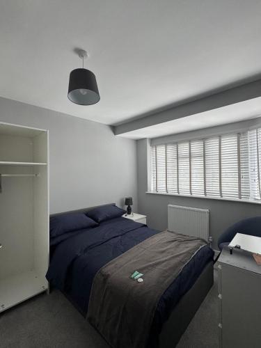 a bedroom with a blue bed and a window at Ravenscourt House in Bristol