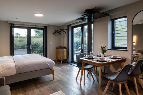 a bedroom with a bed and a table and chairs at Uno Carbis Bay - Boutique Luxury Accommodation in Carbis Bay