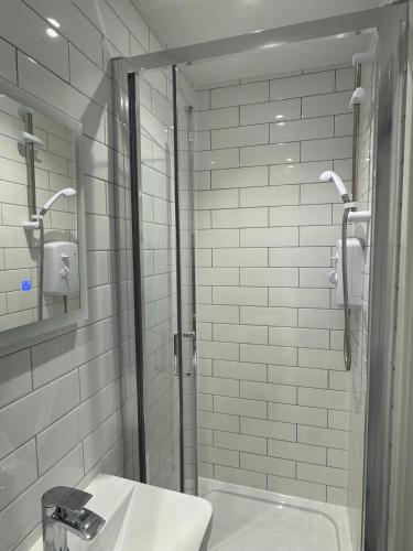 a bathroom with a shower and a sink and a mirror at Ravenscourt House in Bristol