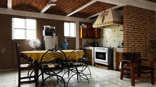 a kitchen with a yellow table and chairs in it at Casa Ttorrez in San Miguel de Allende