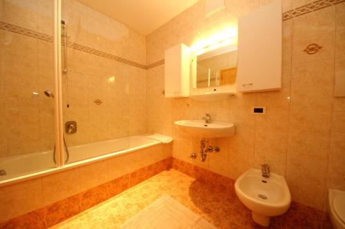 La salle de bains est pourvue d'un lavabo, de toilettes et d'une douche. dans l'établissement Pensione La Müda, à Badia
