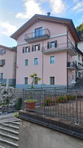 a pink building with a fence in front of it at Casa Vacanze Tel 121 in Pieve Tesino