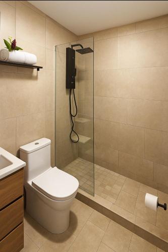 a bathroom with a toilet and a glass shower at Hotel Boutique 4 Estancias in San Ramón