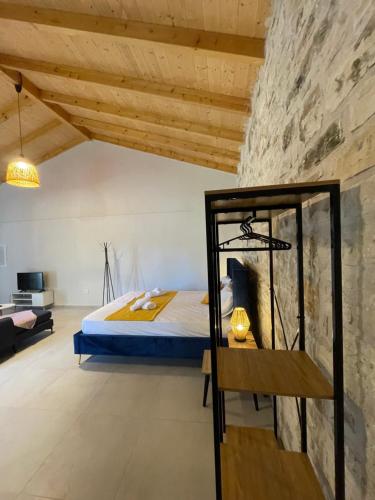 a bedroom with a bed and a stone wall at Casa Diatsenta in Bogdanátika