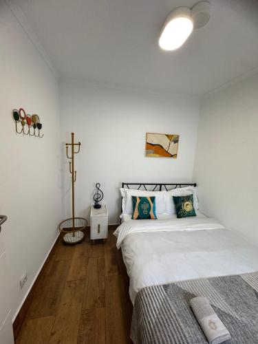 a bedroom with two beds and a cross on the wall at Cascais Garden House 102 in Cascais