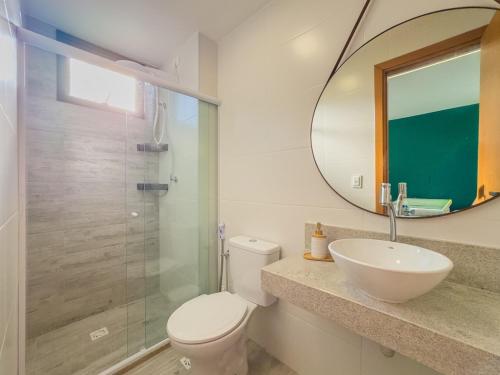 a bathroom with a toilet and a sink and a mirror at Duplex com Piscina Privativa em Itacimirim! in Camaçari