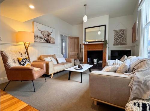 a living room with two couches and a fireplace at Best Location in Hobart! Luxury 4 bedroom with stunning views in Hobart