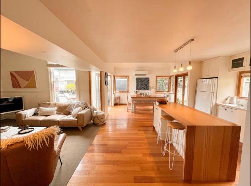 a kitchen and living room with a couch and a table at Best Location in Hobart! Luxury 4 bedroom with stunning views in Hobart