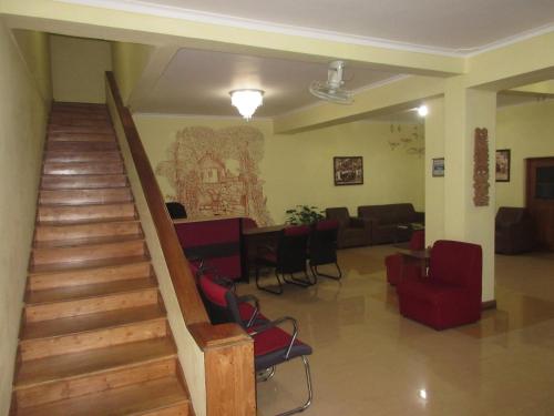 a lobby with a staircase and chairs and a couch at Nature Walk Resort in Kandy