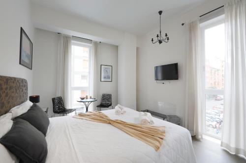 a bedroom with a white bed and a tv at G House in Bologna