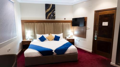 a hotel room with a bed with blue and yellow pillows at Maidan Al Bait in Mecca