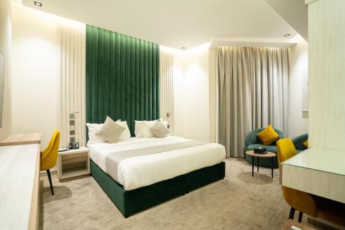 a hotel room with a bed and a green wall at شقق جلف نايت للشقق المخدومة in Riyadh