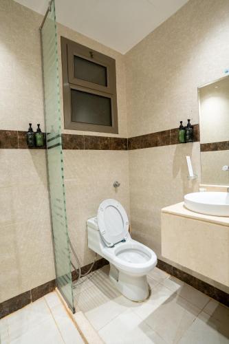 a bathroom with a toilet and a sink at شقق جلف نايت للشقق المخدومة in Riyadh