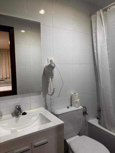 a bathroom with a sink and a toilet and a mirror at Hostal Casa Casado in Belver