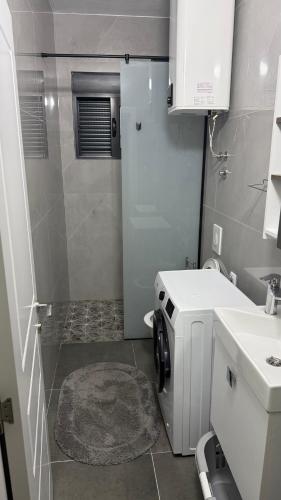 a bathroom with a sink and a washing machine at Morea Apartments in Ulcinj