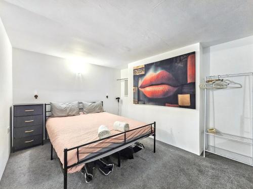a bedroom with a bed and a painting on the wall at Hidden Putney-Studio Flat in London