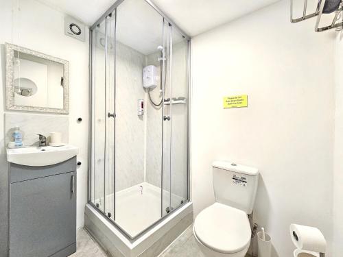 a bathroom with a shower and a toilet and a sink at Hidden Putney-Studio Flat in London