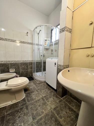 a bathroom with two toilets and a sink and a shower at Casa Dos Avenidas 4 Dormitorios in Montevideo