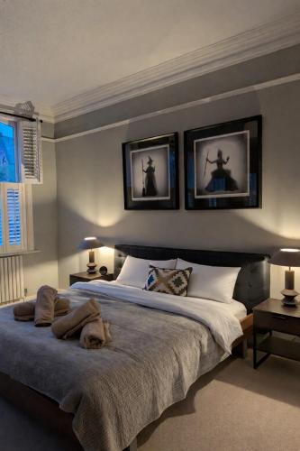 a bedroom with a bed with three pictures on the wall at Stylish Leeds City Centre Retreat with Private Terrace & Hottub in Central Station