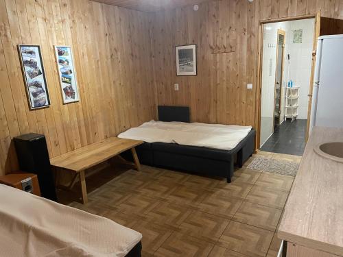 a room with a bed and a table and a refrigerator at Pusa Saunamaja in Jõhvi
