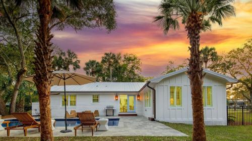 a white house with palm trees in front of it at Sawyer by AvantStay Stunning Isle Of Palms Home w Pool in Isle of Palms