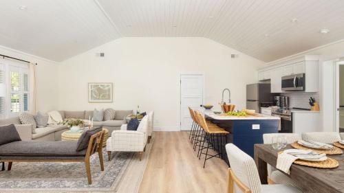 a kitchen and living room with a table and chairs at Sawyer by AvantStay Stunning Isle Of Palms Home w Pool in Isle of Palms