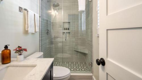 a bathroom with a shower with a toilet and a sink at Sawyer by AvantStay Stunning Isle Of Palms Home w Pool in Isle of Palms