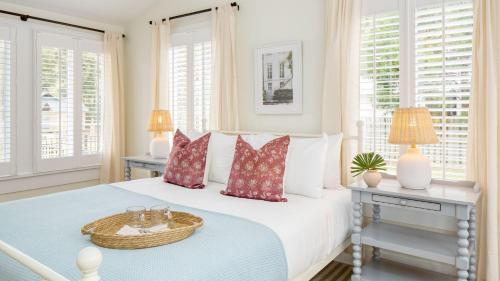 a white bedroom with a bed with a basket on it at Sawyer by AvantStay Stunning Isle Of Palms Home w Pool in Isle of Palms