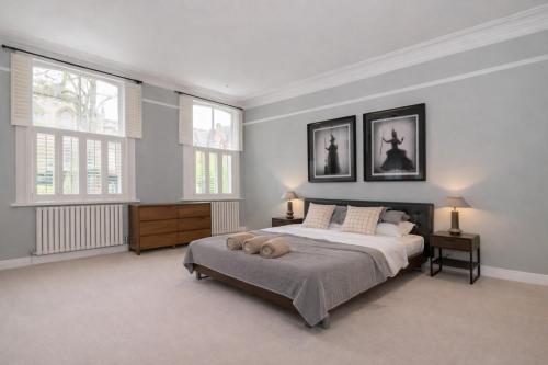 a bedroom with a large bed and two windows at Stylish Leeds City Centre Retreat with Private Terrace & Hottub in Central Station