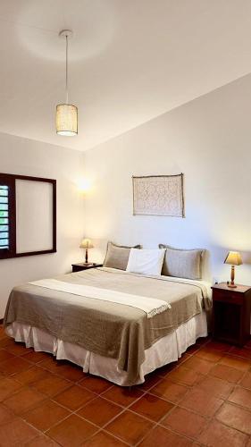 a bedroom with a large bed with two night stands at Vila Tao in Fortim