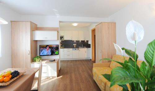 a living room with a couch and a kitchen at Suvendes Apartments in Prato allo Stelvio