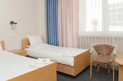 a room with two beds and a table and a chair at Vistula Hotel in Świecie