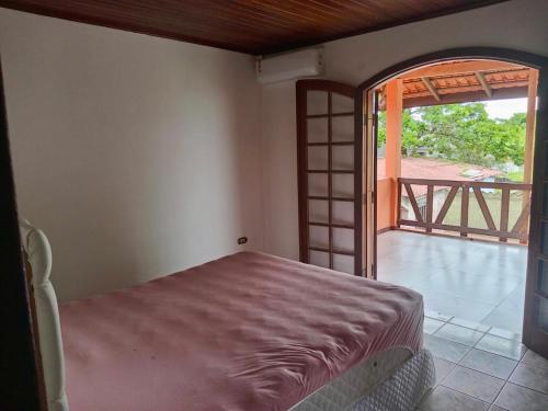 a bedroom with a bed and an open door at Sobrado em Coroados, Guaratuba PR in Guaratuba