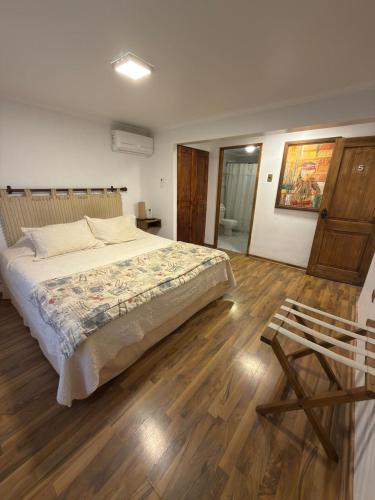 a bedroom with a large bed and a wooden floor at Tierra & Vino a pasos Museo y Casino in Santa Cruz