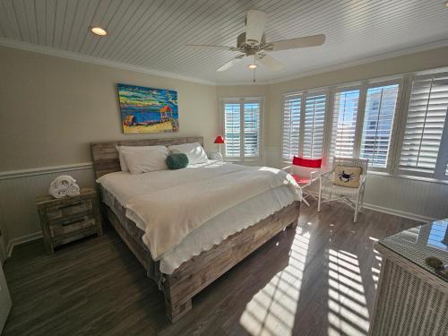 a bedroom with a large bed with a ceiling fan at HB303 My Flippin' House in Holden Beach