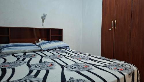 a bedroom with a bed with a black and white comforter at Posada Ernesto in Rauch