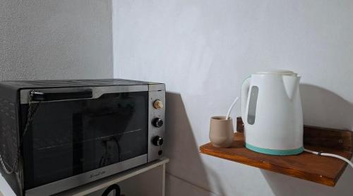 a microwave and a pitcher on a wooden shelf at Posada Ernesto in Rauch