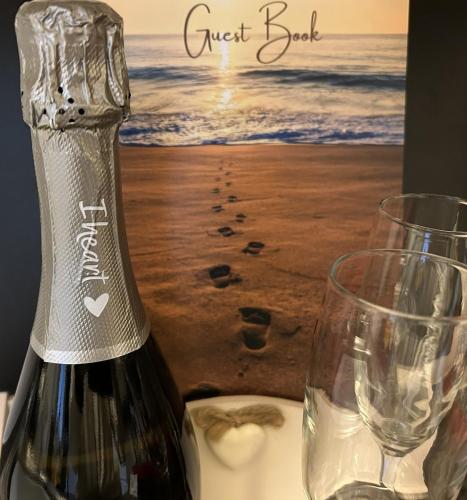 a bottle of wine sitting next to a glass at Chapel St Apartments in Caernarfon