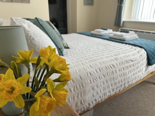 a bedroom with a bed with yellow flowers on it at Chapel St Apartments in Caernarfon